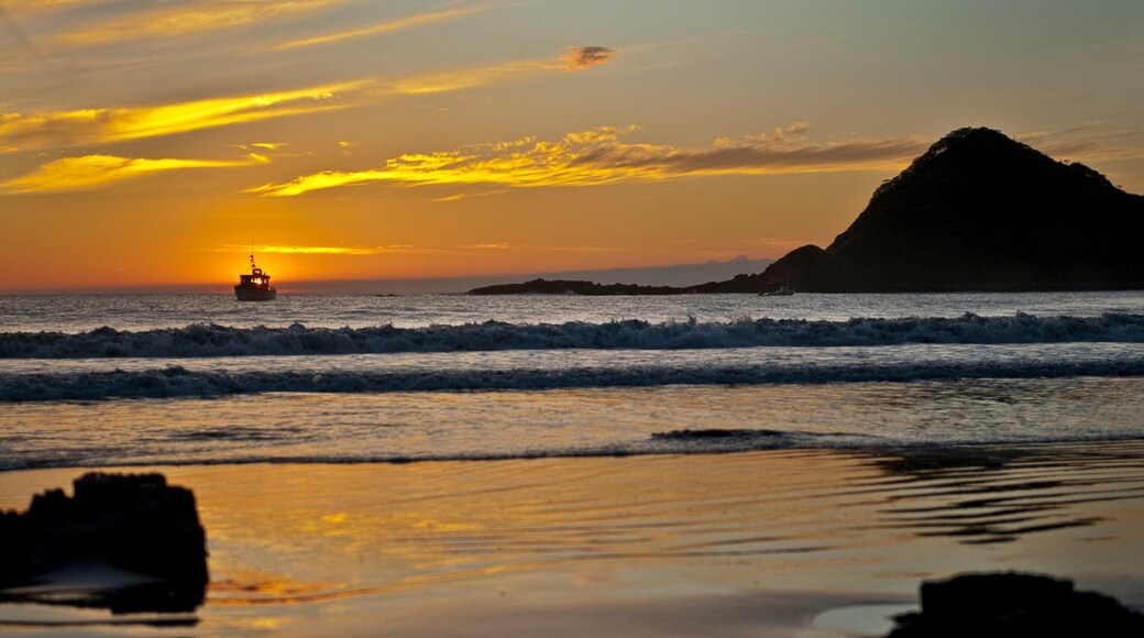 Nicaragua featuring a sunset, rocky coastline and surf
