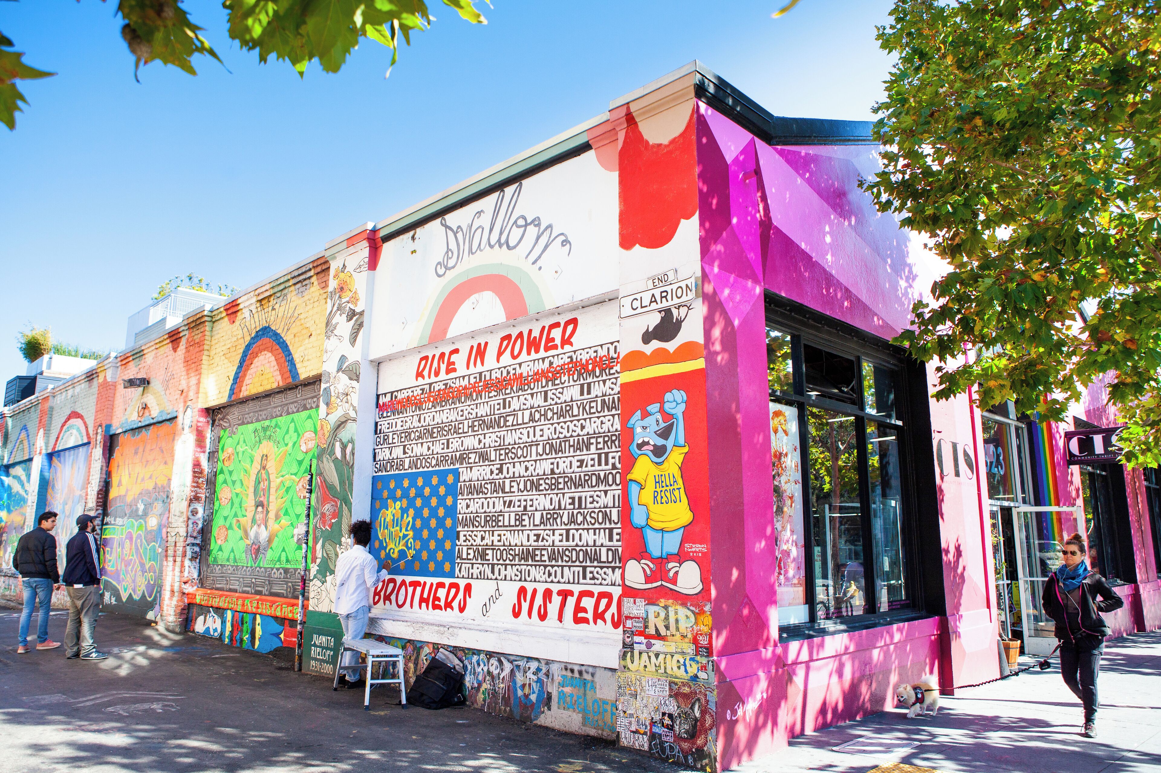 A colorful mural with graffiti and a rainbow on a building.