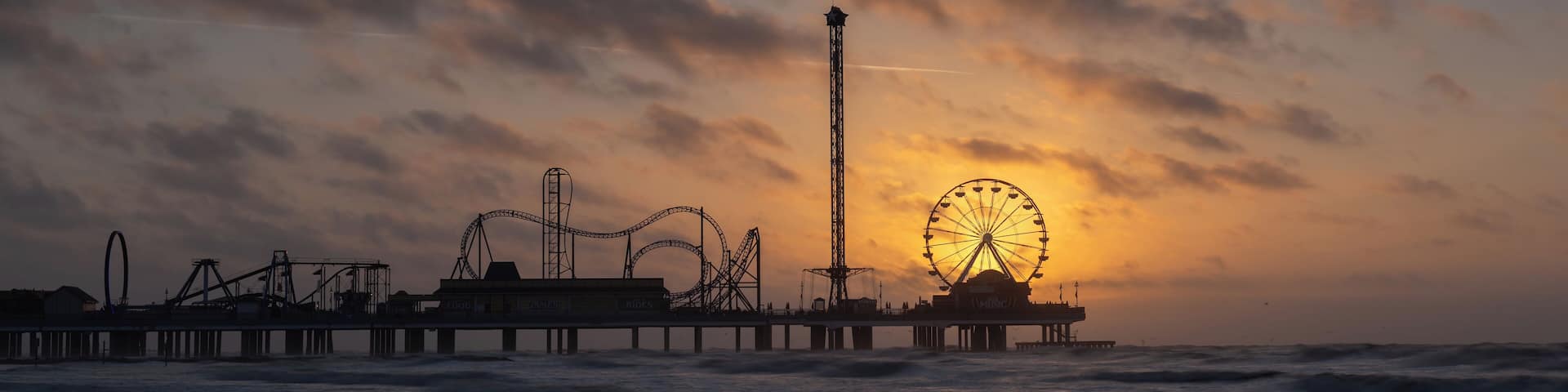 Sunrise at the historic pleasure pier in Galveston, TX. I visited Galveston for a brief business trip and had the opportunity to take a couple of photos on two mornings. This morning was very windy but despite the forecast the sun revealed itself as planned behind the ferris wheel