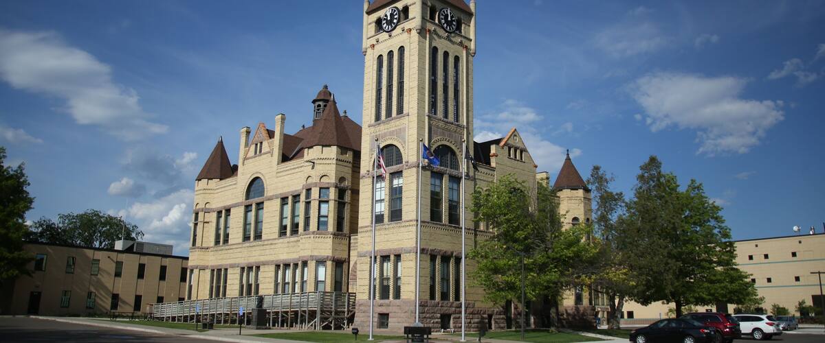 A historic building with a clock tower, large windows, and a prominent entrance.