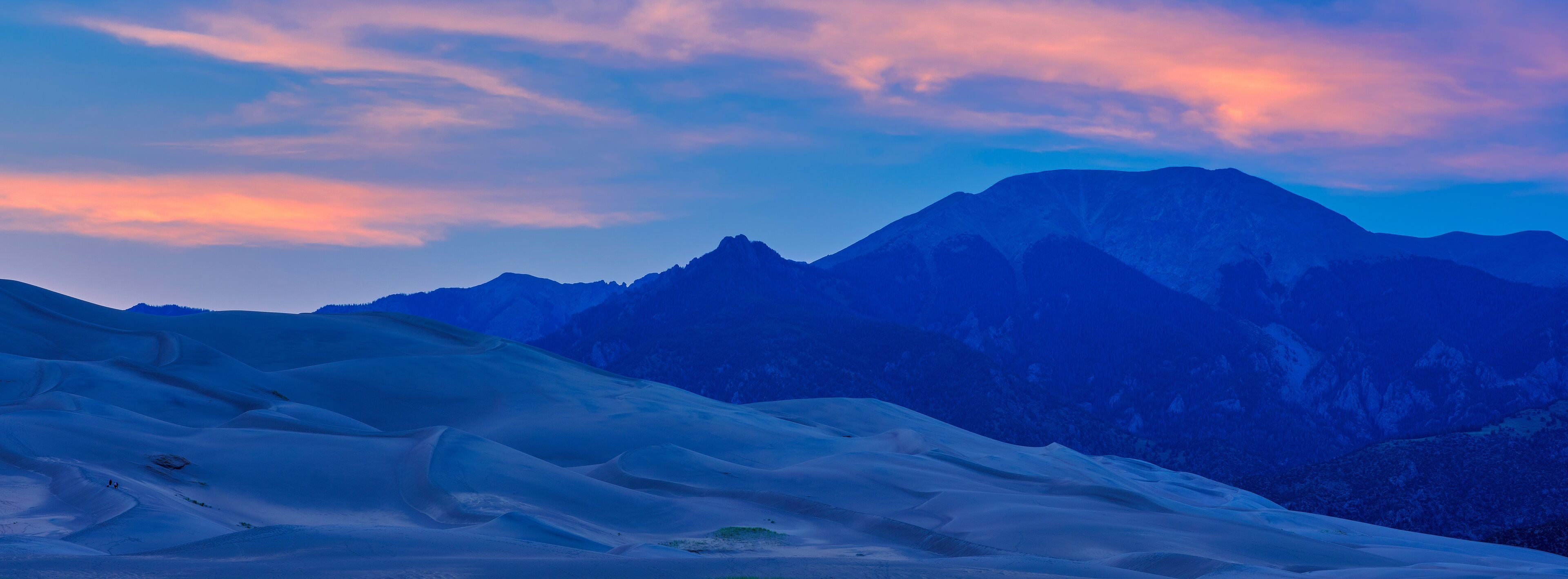 Panoramic image of large sand dunes at sunset and dusk on Colorado