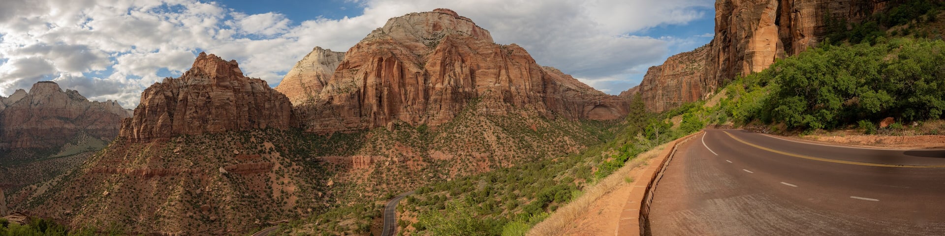 A winding road through a mountainous landscape with rocky cliffs and sparse vegetation.
