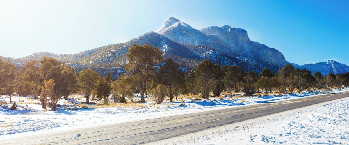 A snow-covered road with mountains in the background.