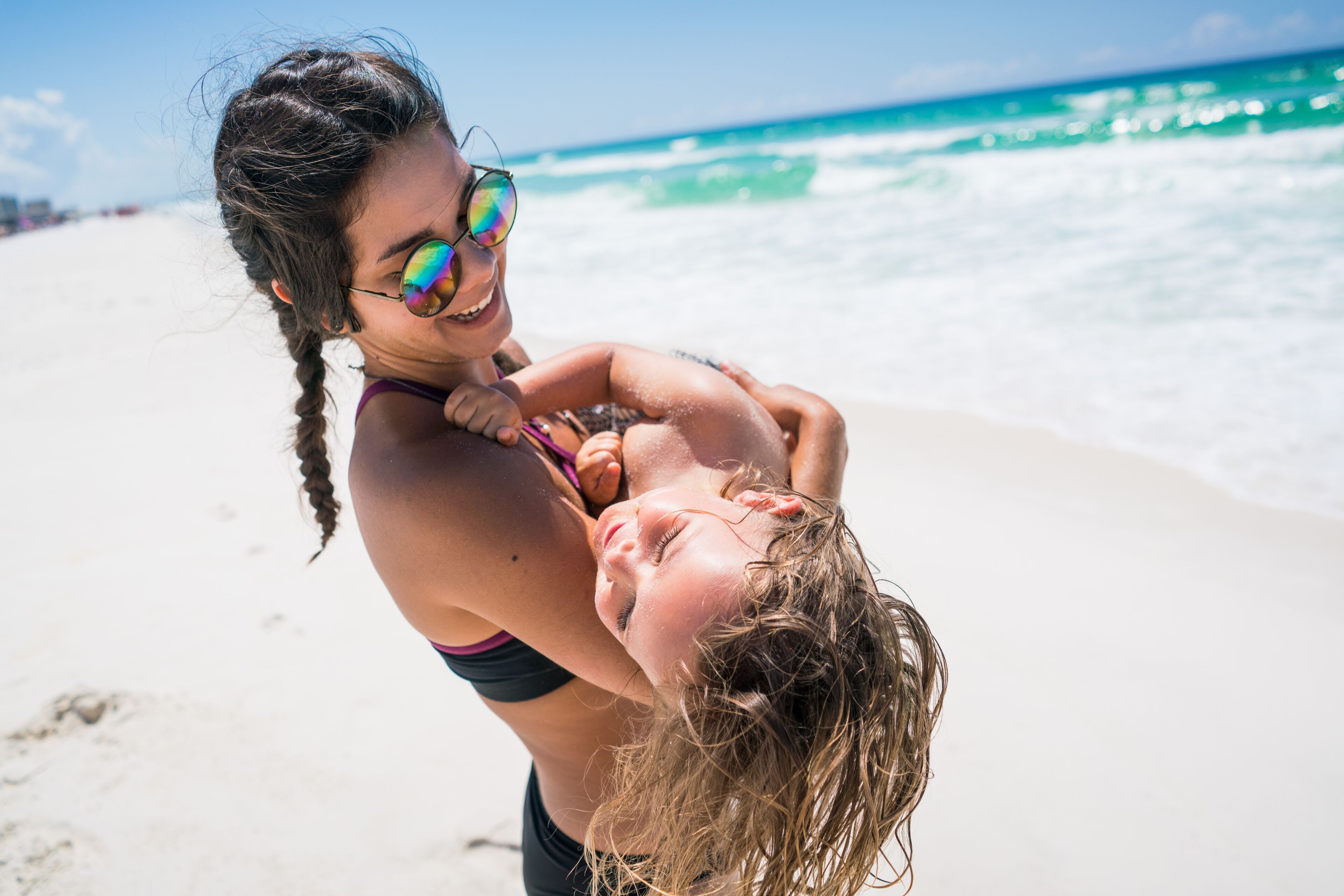 Woman Carrying Child on Beach