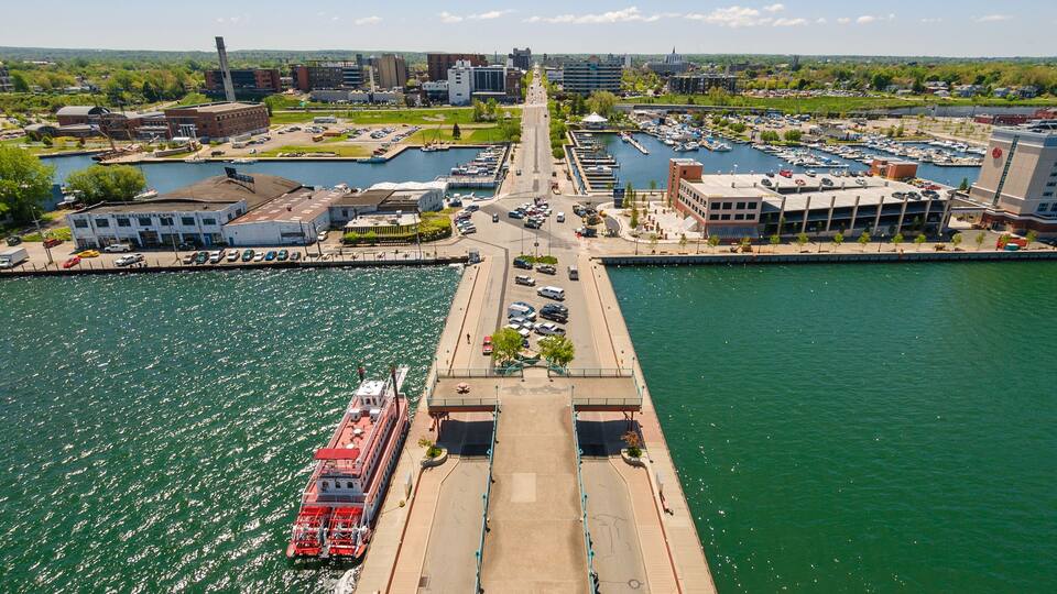 A riverfront with a bridge, marina, and buildings along the banks.