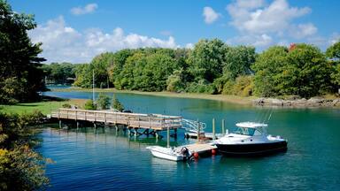A calm river with a wooden dock and two boats moored at the pier.