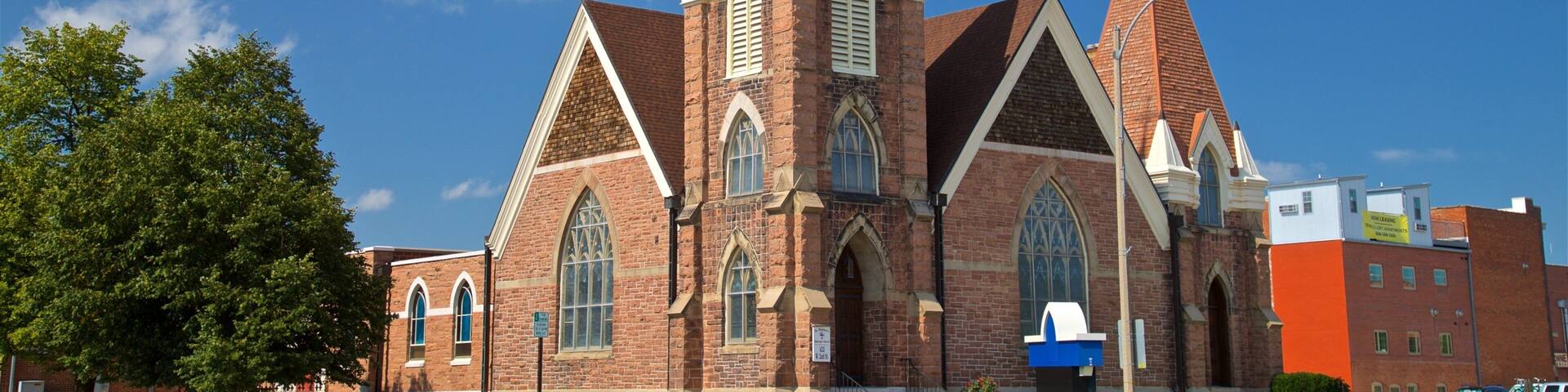 A large brick church with a tall steeple and multiple pointed towers.