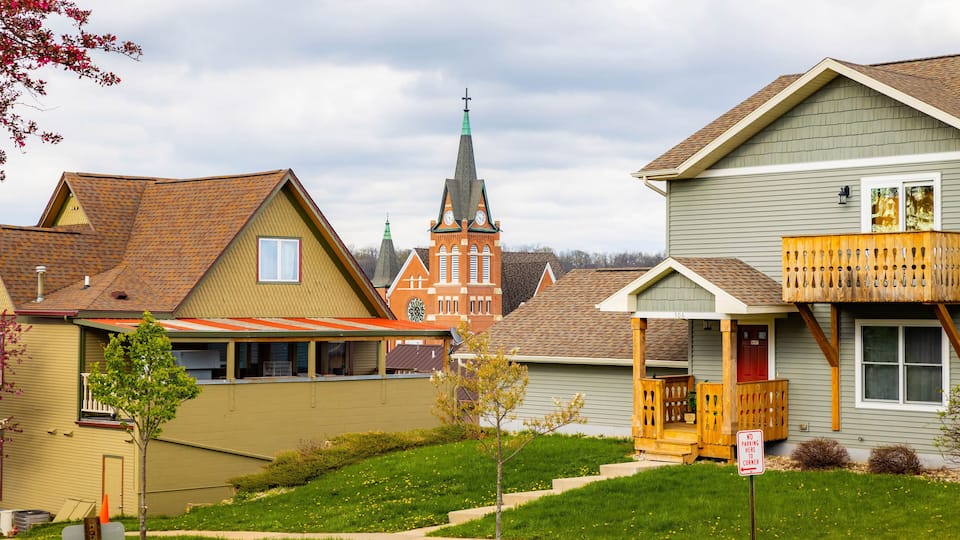 A residential neighborhood with houses, a church, and a clear sky.