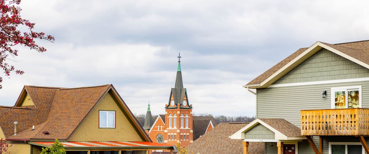 A residential neighborhood with houses, a church, and a clear sky.