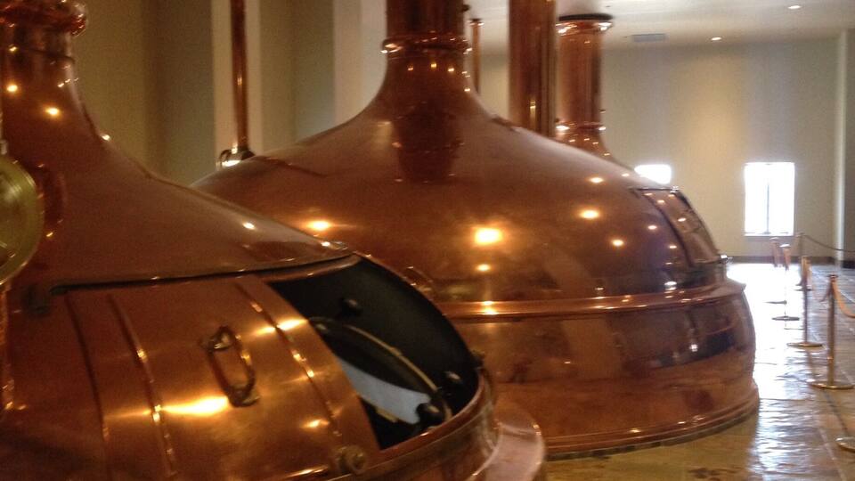Large copper distillation columns in a building.