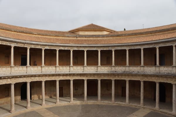 A circular courtyard with a central open space surrounded by colonnades and a tiled roof.