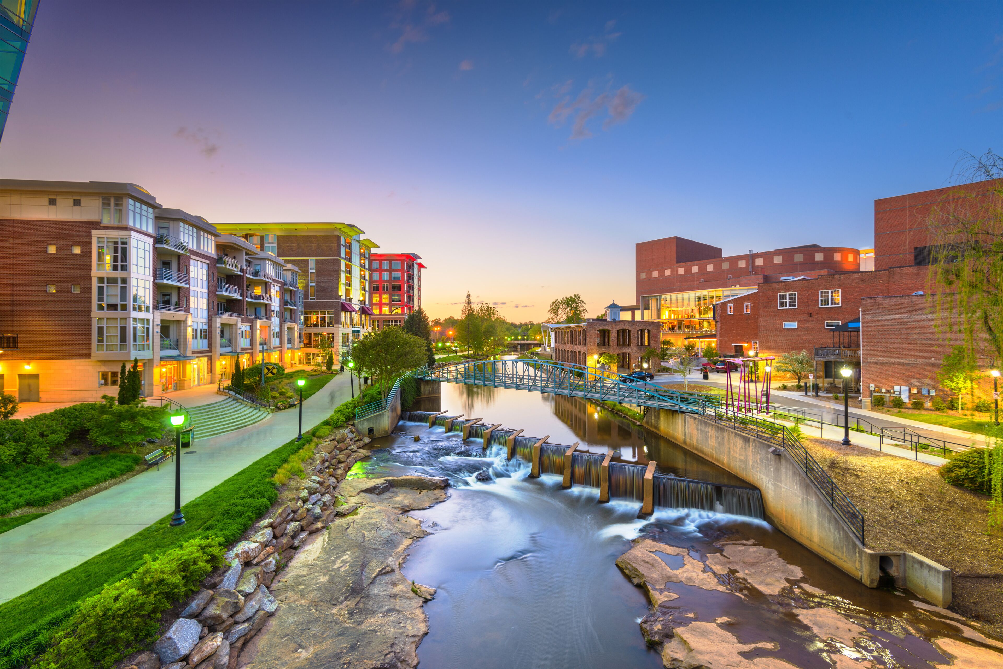 Greenville, South Carolina, USA downtown cityscape on the Reedy River at dusk