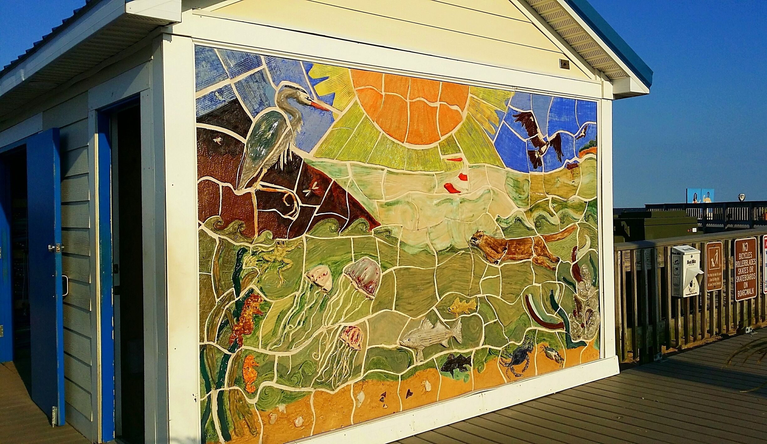 A mosaic mural on a building's exterior depicting marine life.
