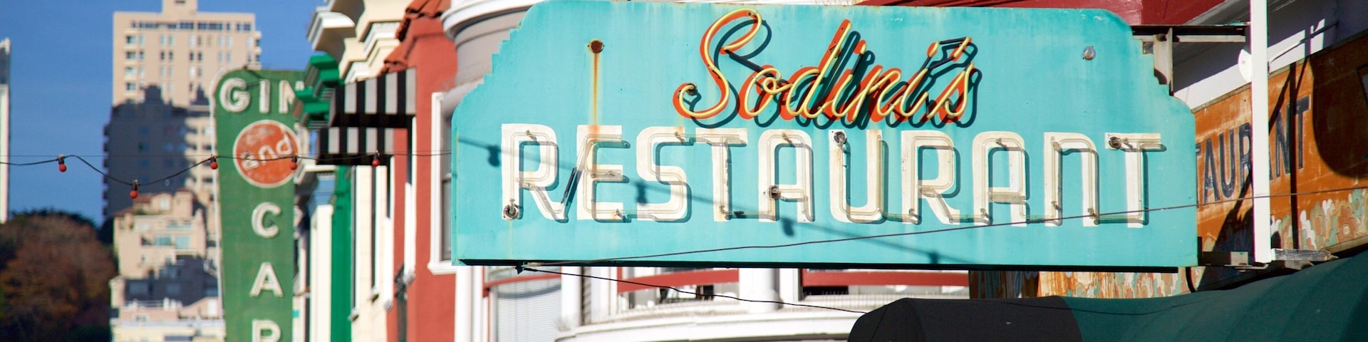 Placa antiga para 'Sodini's Restaurant' com design retrô, com um cenário de edifícios históricos e coloridos.