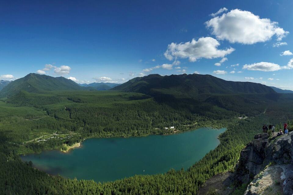 A lake surrounded by mountains and dense forests.
