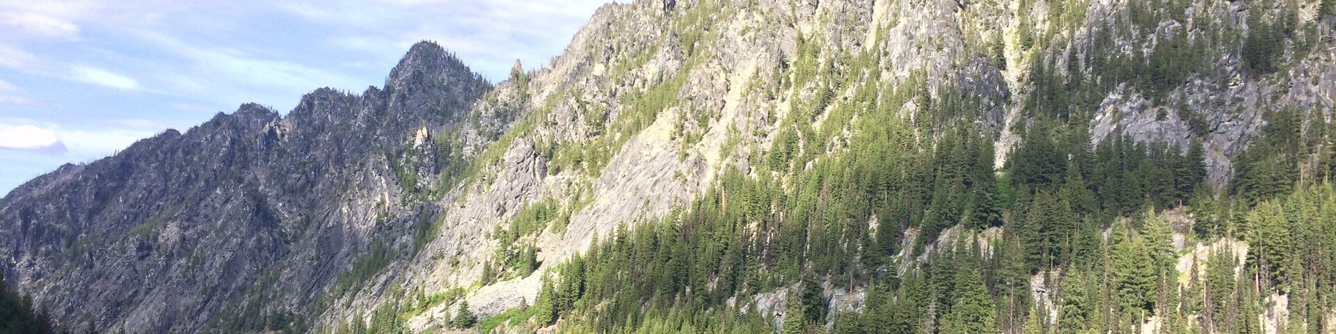 A mountainous landscape with dense forests and rocky cliffs.
