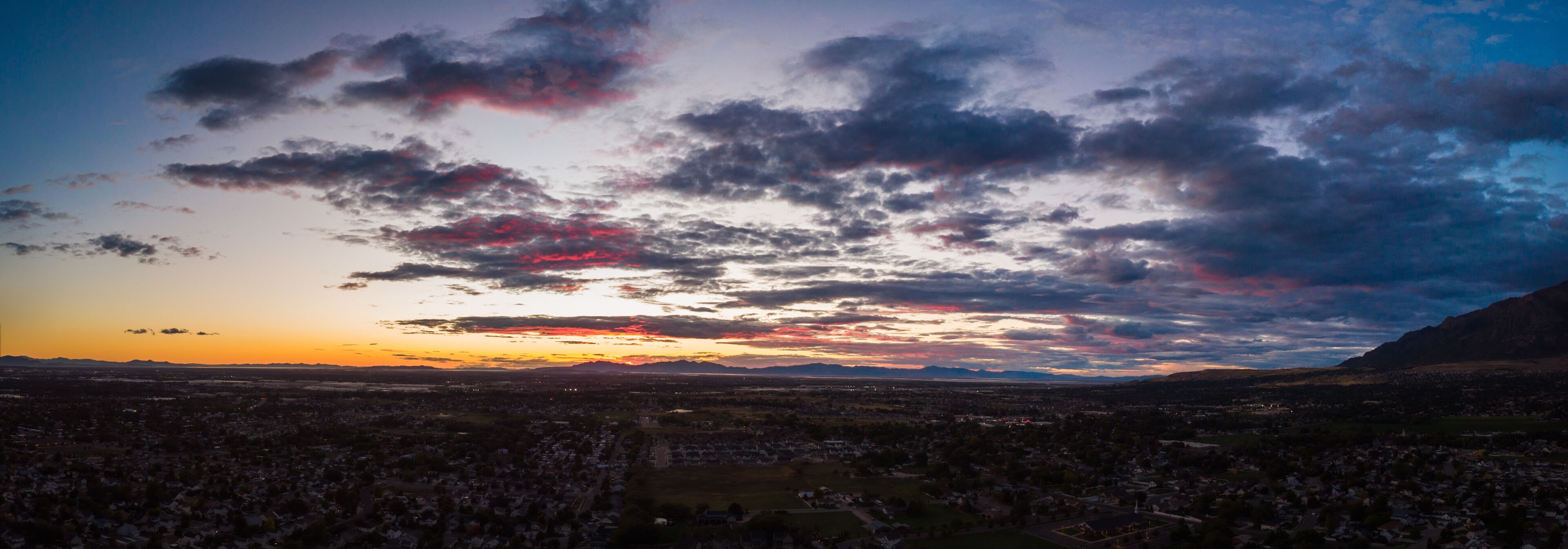 A sunset over a cityscape with mountains in the background.