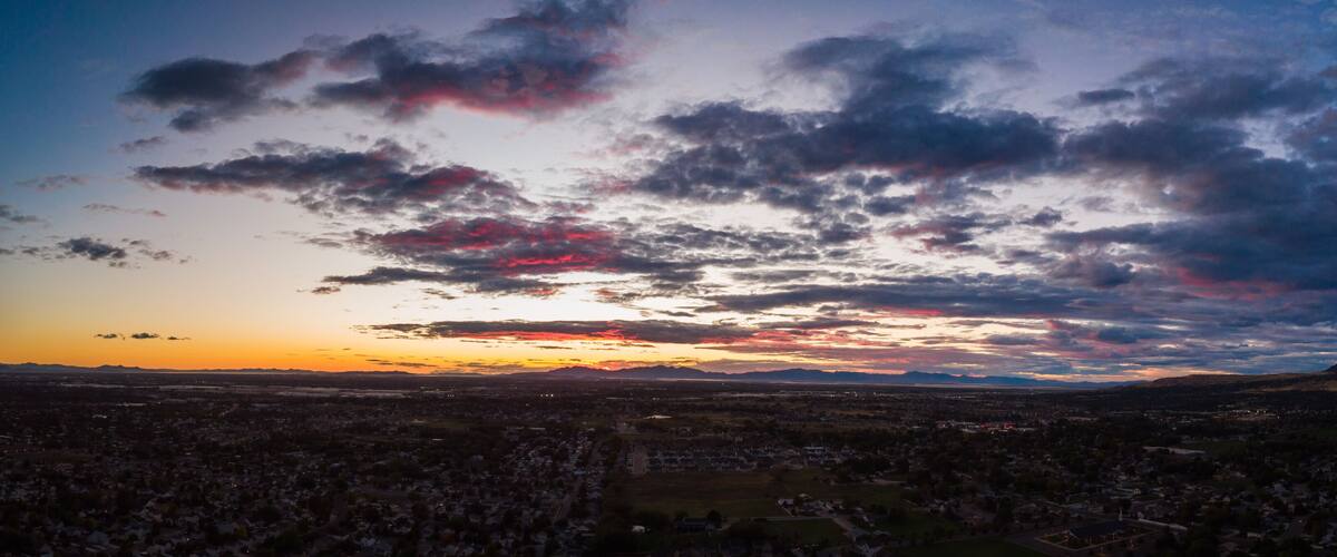 A sunset over a cityscape with mountains in the background.