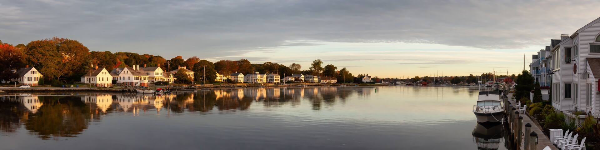 Panoramic view of residential homes by the Mystic River during a vibrant sunrise. Taken in Mystic, Stonington, Connecticut, United States.