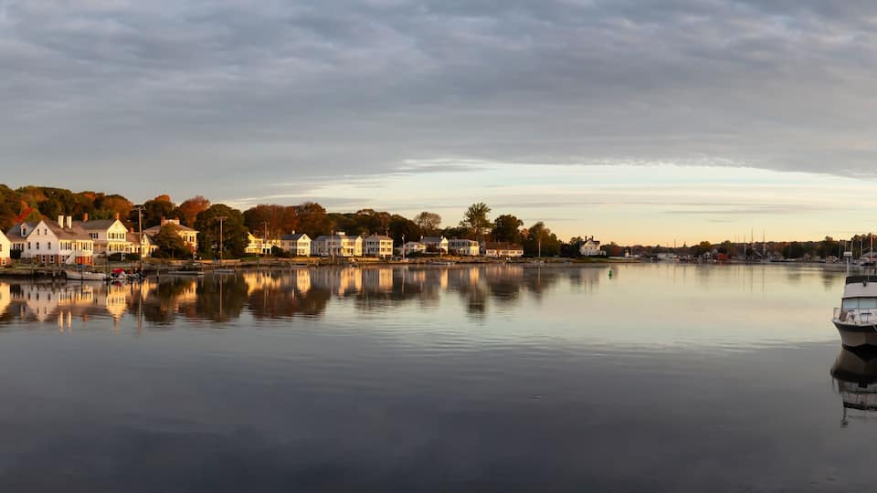 Panoramic view of residential homes by the Mystic River during a vibrant sunrise. Taken in Mystic, Stonington, Connecticut, United States.