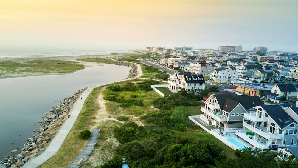 A coastal residential area with houses, a beach, and a waterway.