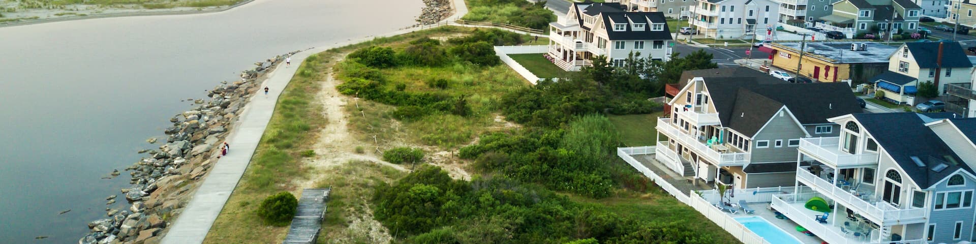 A coastal residential area with houses, a beach, and a waterway.