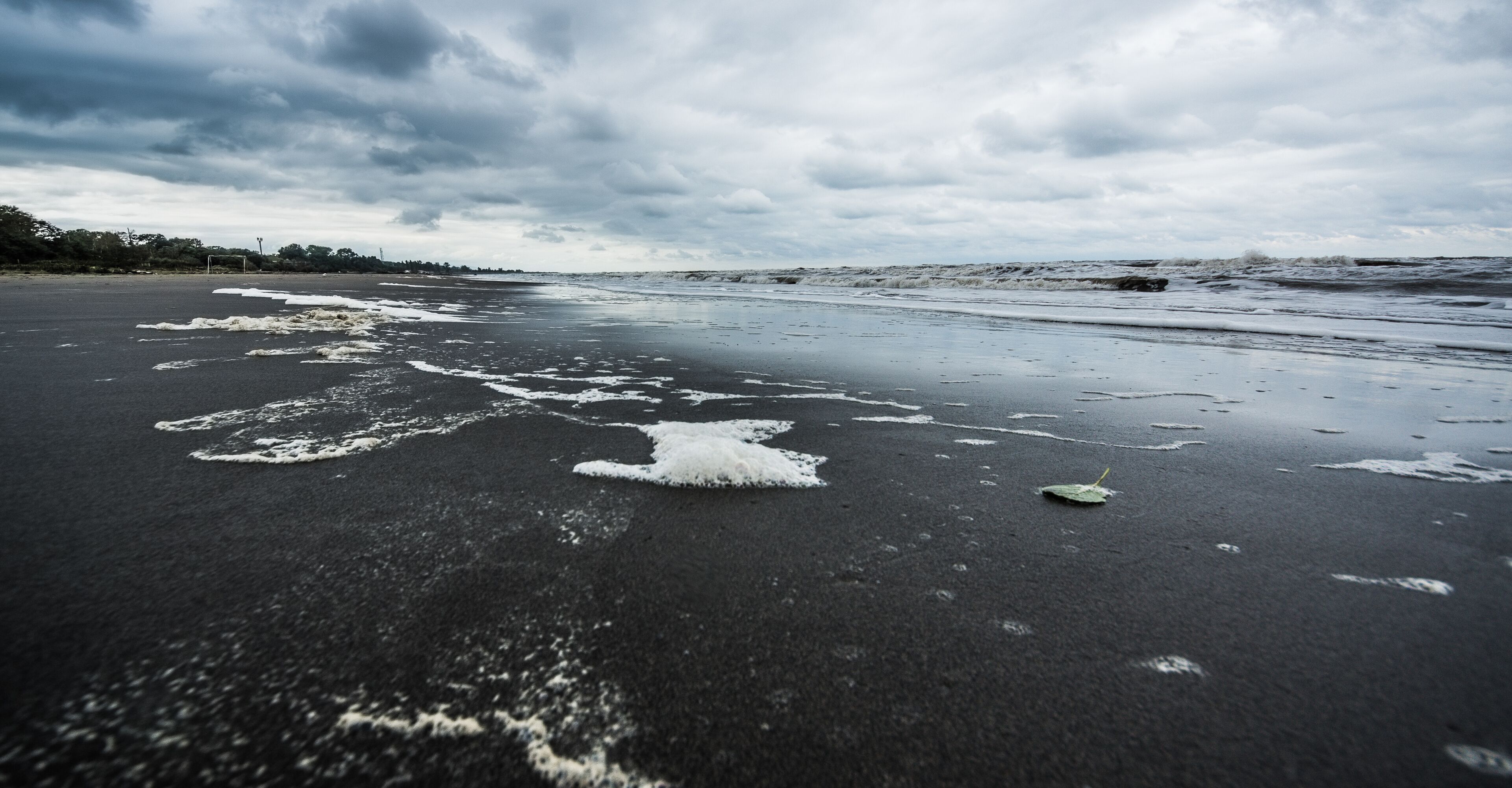 A beach with wet sand and waves.