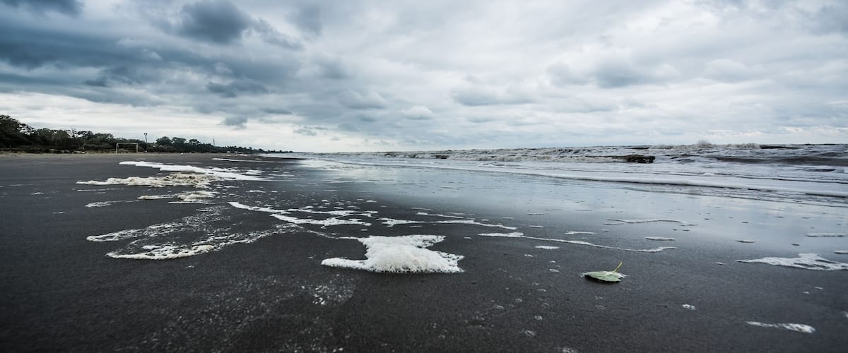A beach with wet sand and waves.