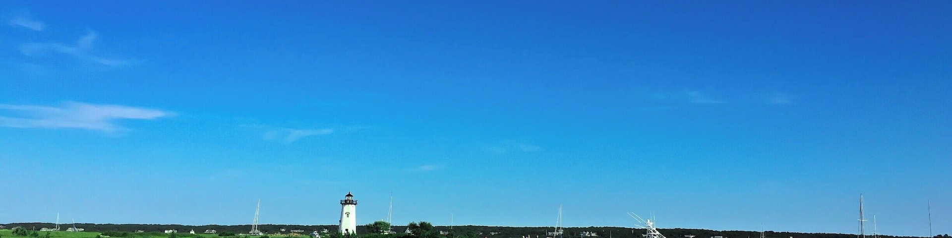 Sandy beaches, farmlands, fishing docks, harbor towns and tall lighthouses, Its Martha's Vineyard! It is around an hour of boat ride from Cape Cod to the Oak Bluffs. MV accessible only by boat or air.
This picture was of course taken in summer :) Bright sunny day with blue sky and lush green. In the background is the famous east chop lighthouse. The best of my memories of MV are from East Chop. We rented a bright Red scooter near the Oak Bluffs harbor after getting off from ferry, kicked off our slippers, rode to the sunset ;) I meant we drove to East Chop:)
Must Do : Get that pretty but awfully slow red scooter, drive to the light house, live the dream :)
