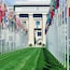 A building with the United Nations logo, surrounded by rows of international flags.