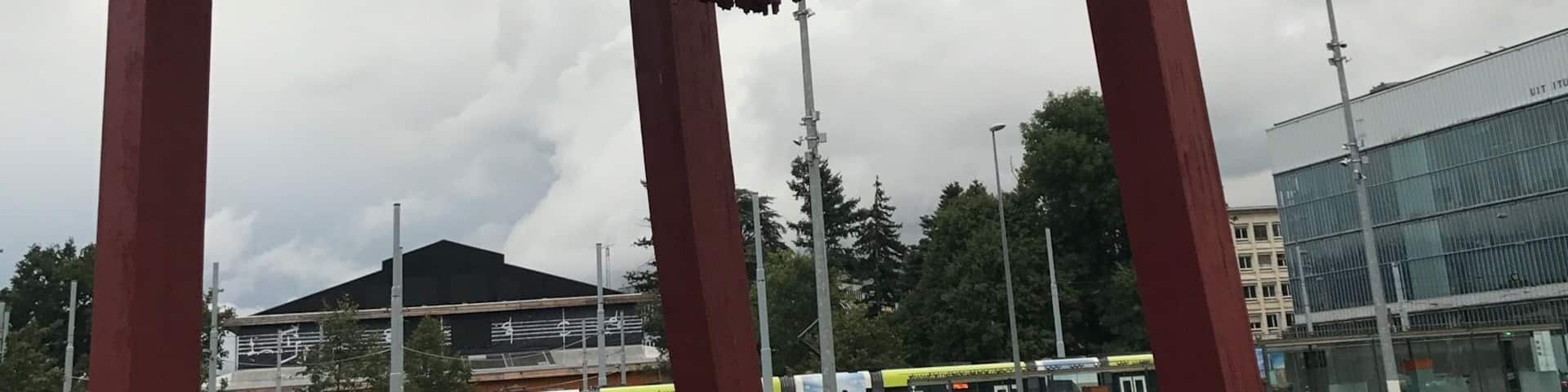Una escultura grande de una silla roja en una plaza abierta.