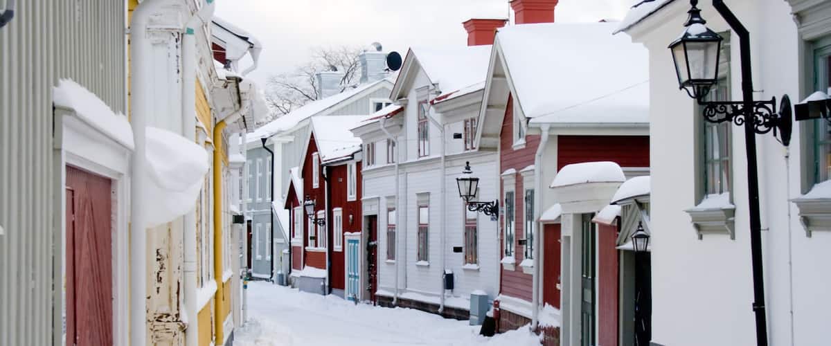 A snow-covered street lined with colorful houses.