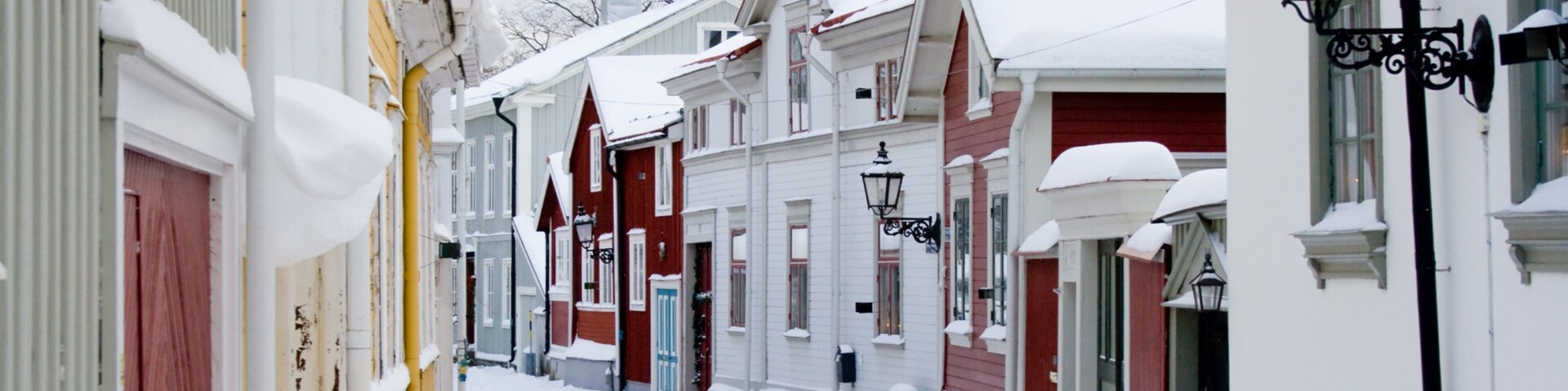 A snow-covered street lined with colorful houses.