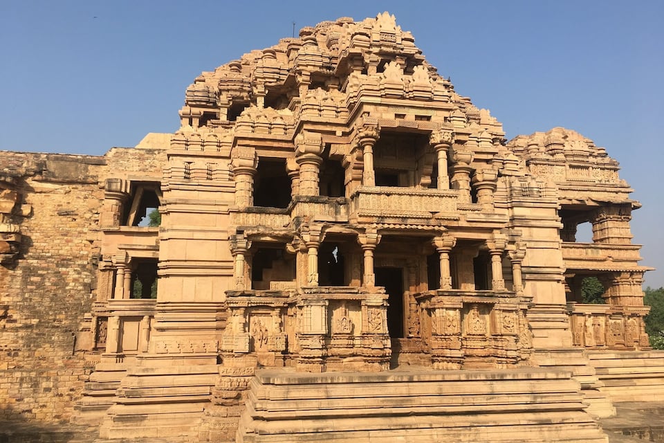 A large, intricately carved temple with multiple tiers and detailed sculptures.