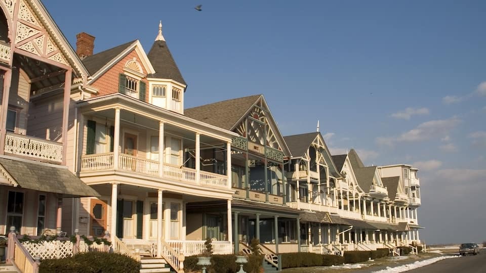 A row of Victorian-style houses with ornate balconies and a clear blue sky.