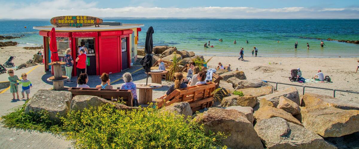 A beachside café with a red exterior and a sign reading "Jungle Beach Break."
