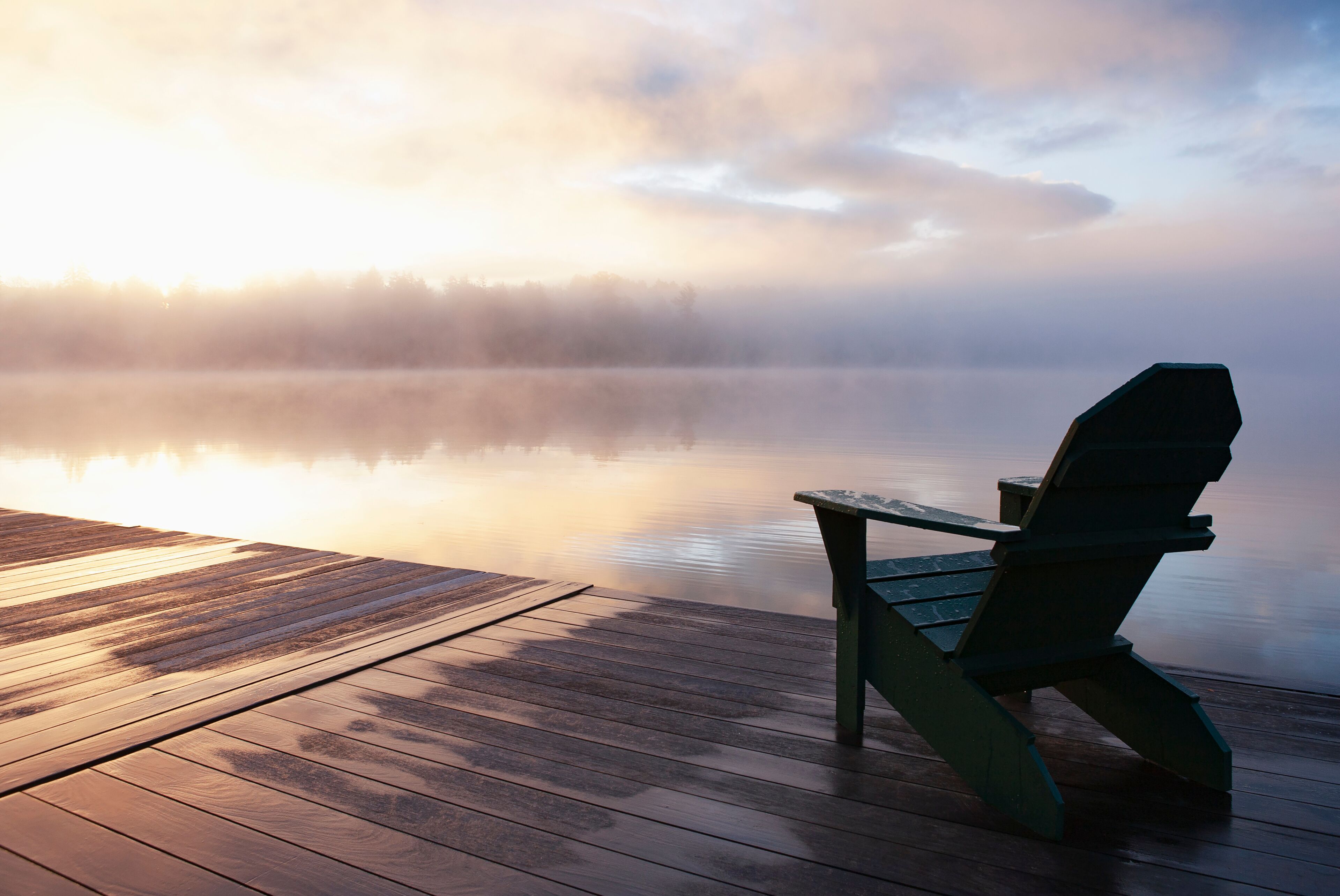 USA, New York, Lake Placid, Adirondack chair on pier at sunrise