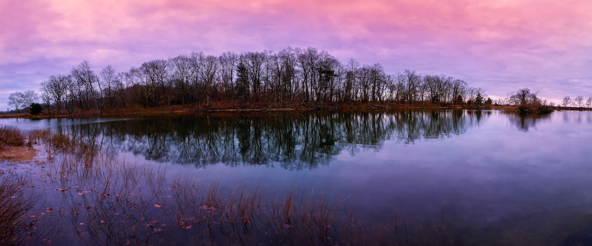 Greenwich Point Park Nature Preserve Sunrise Seascape at Tod's Inlet and Flat Neck Point with an island with Eagle and Osprey Nests, and a stonewall post in Old Greenwich, Connecticut, USA