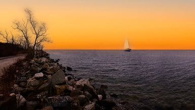 A sailboat on a calm sea during sunset.