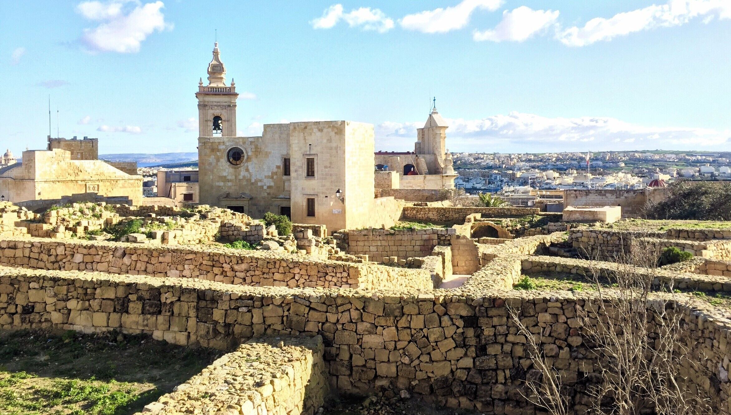 An ancient stone fortress with two prominent towers and a large central building.