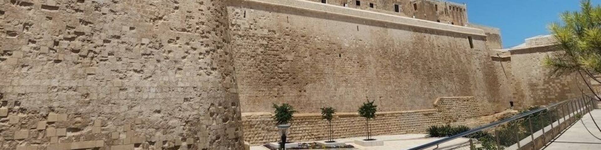 A historic stone fortress with crenellated walls and a flagpole.