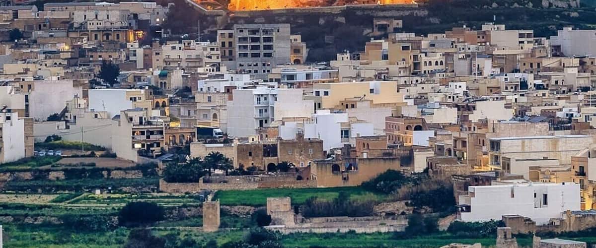 A fortified city with a prominent castle-like structure atop a hill, surrounded by a densely packed urban area with traditional architecture.