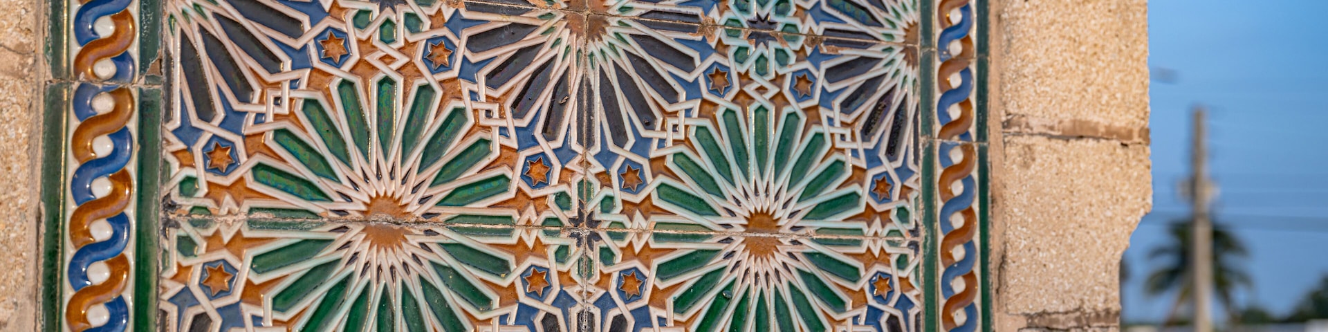 A detailed tile mosaic with geometric patterns and star shapes.