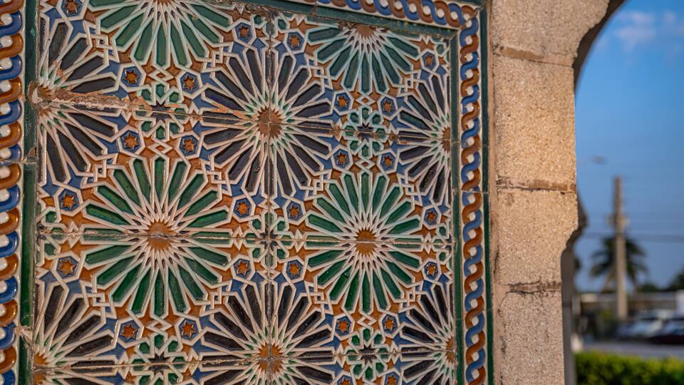 A detailed tile mosaic with geometric patterns and star shapes.