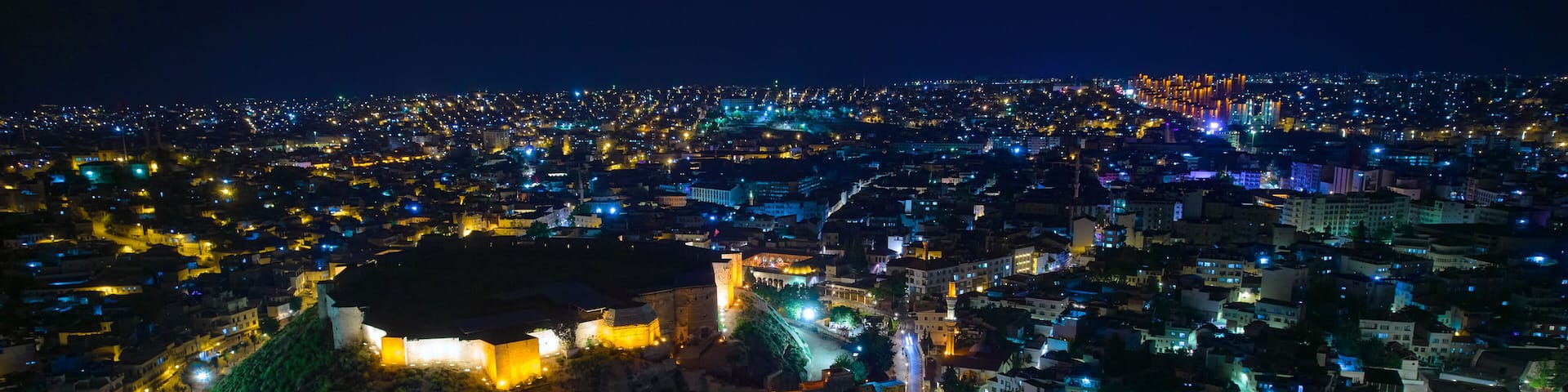 Illuminated Gaziantep Castle and night city lights aerial view