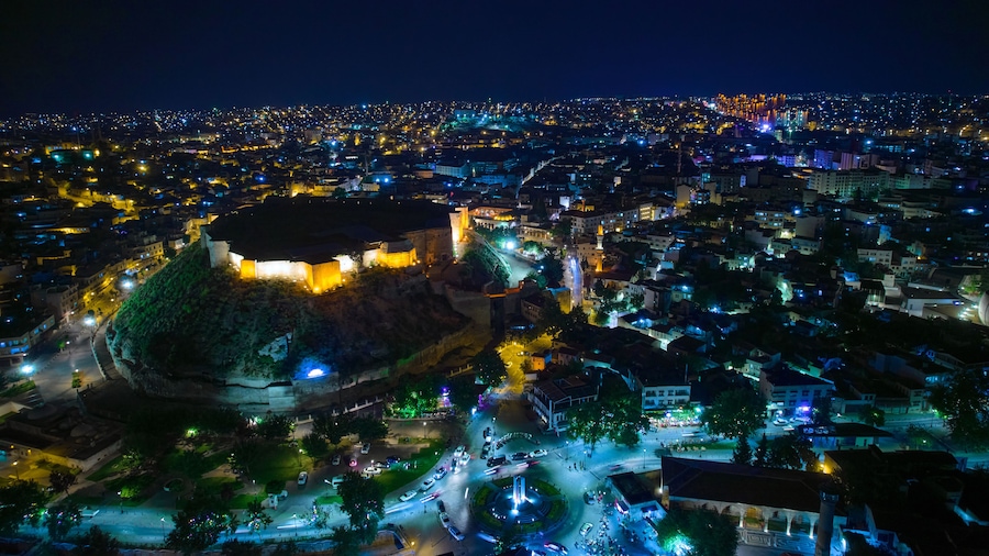 Illuminated Gaziantep Castle and night city lights aerial view