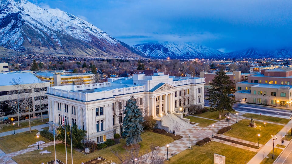 A snow-capped mountain range, a large government building, and a cityscape.