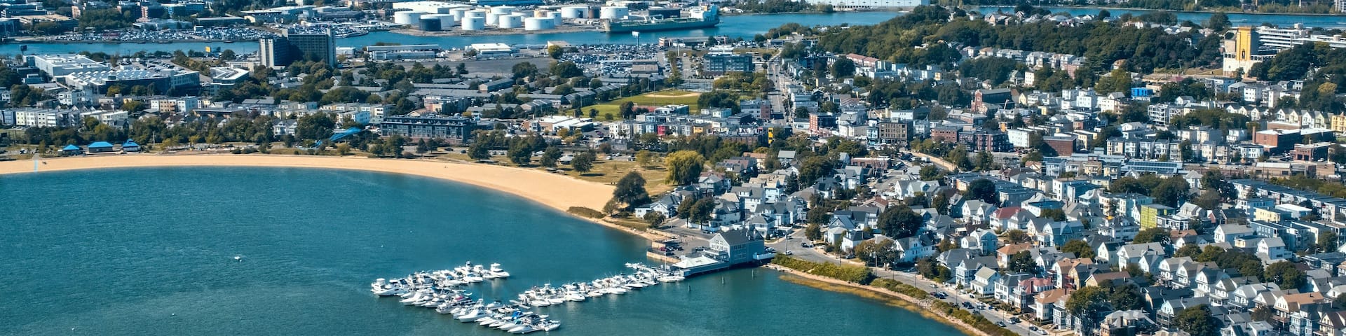 A coastal cityscape with a marina, residential areas, and industrial buildings.