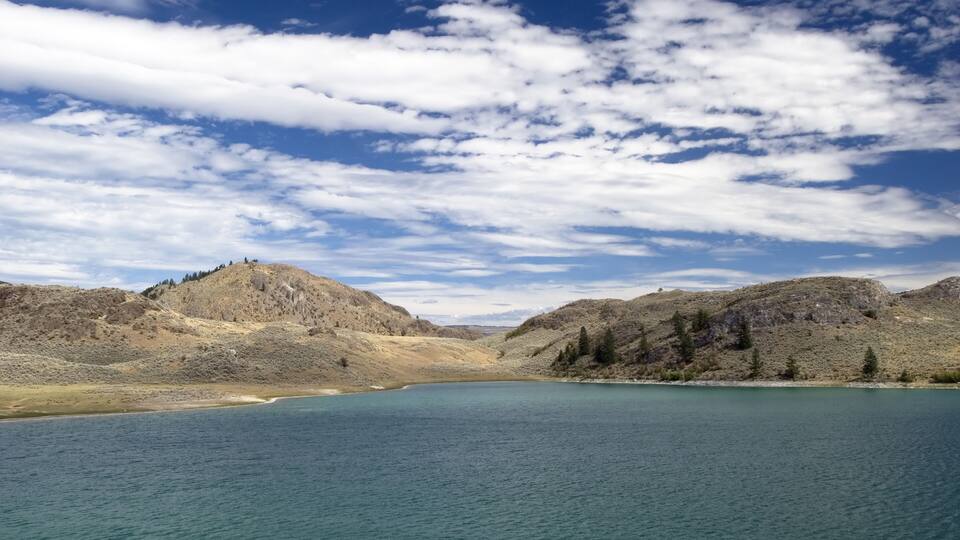 A lake surrounded by mountains and a clear sky.