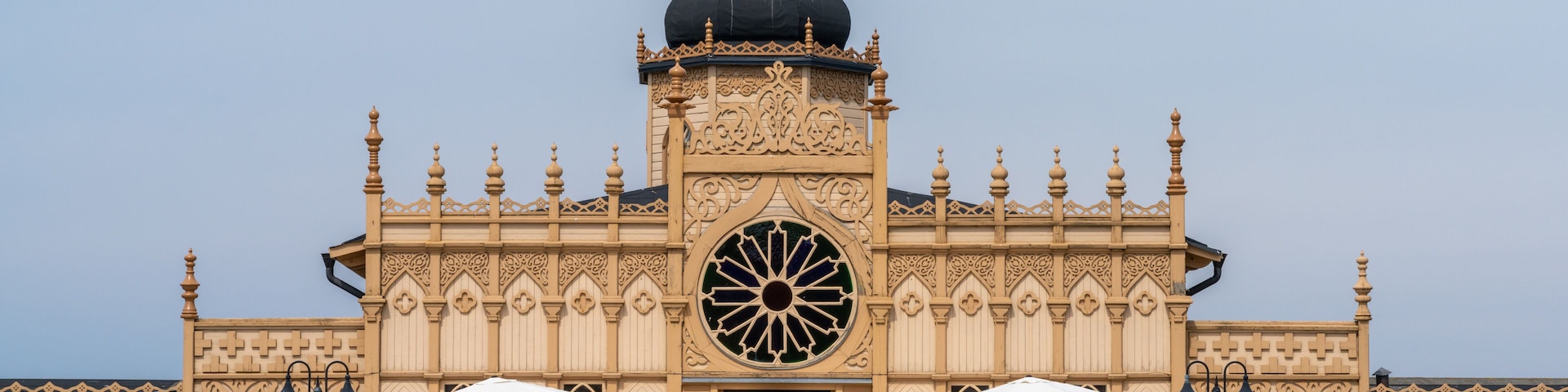 Un edificio con arquitectura ornamentada, un gran ventanal central y una cúpula en la parte superior.